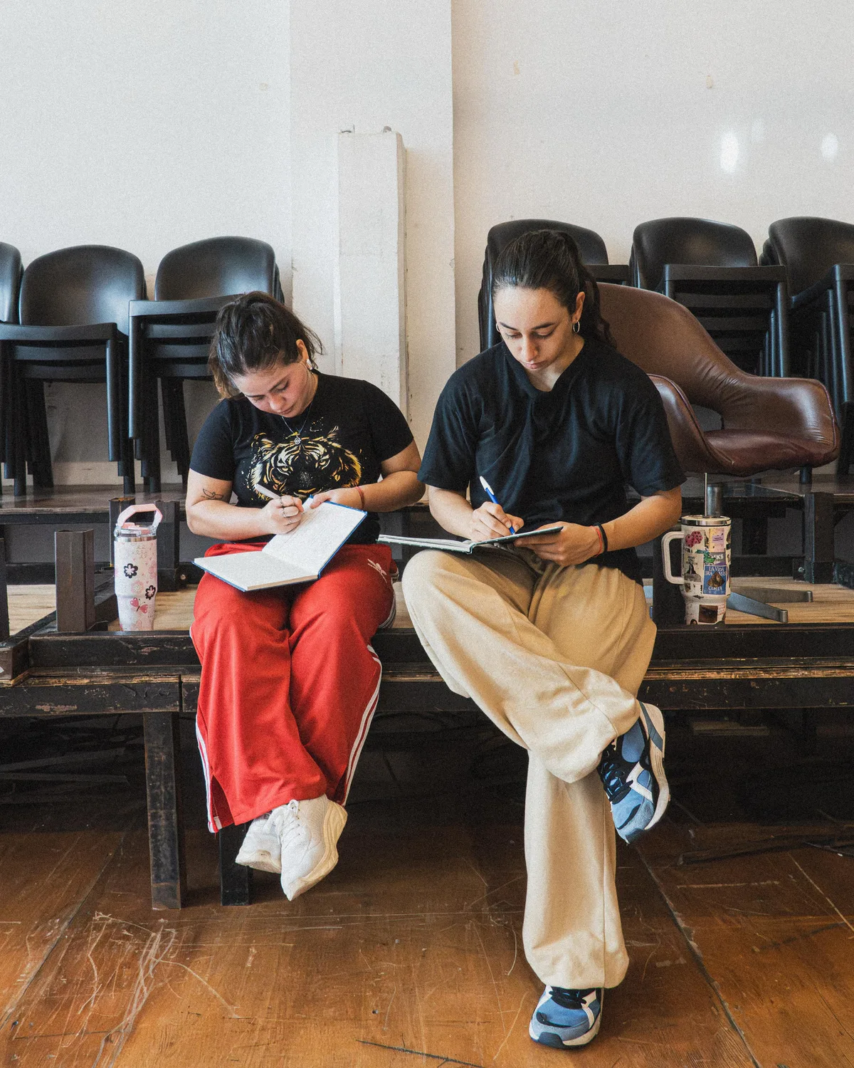 Dos alumnas tomando notas en la plataforma del salón