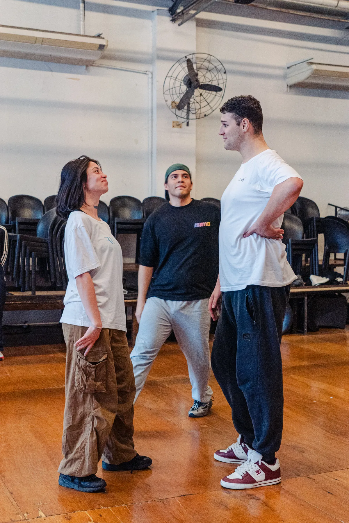 Tres estudiantes conversando durante el ensayo