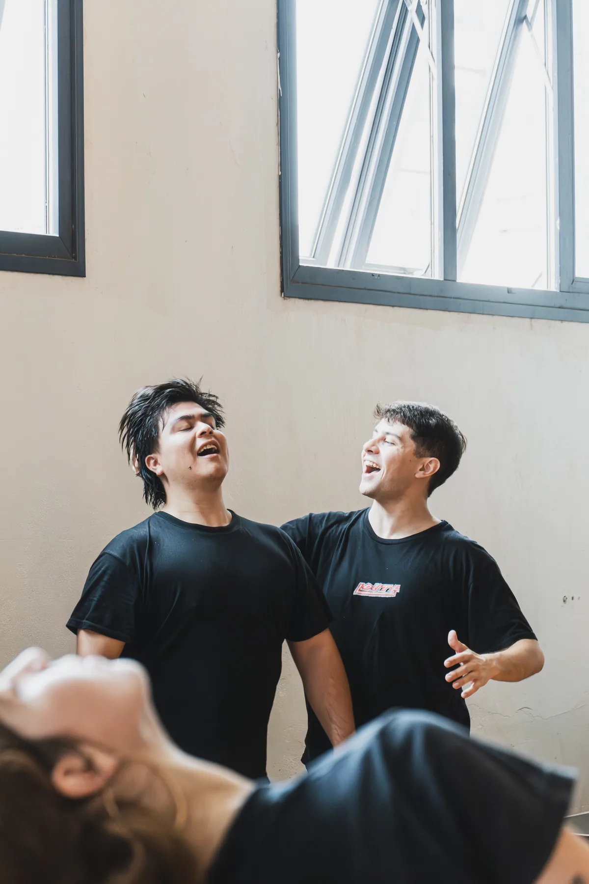 Dos alumnos riendo junto a la ventana del salón